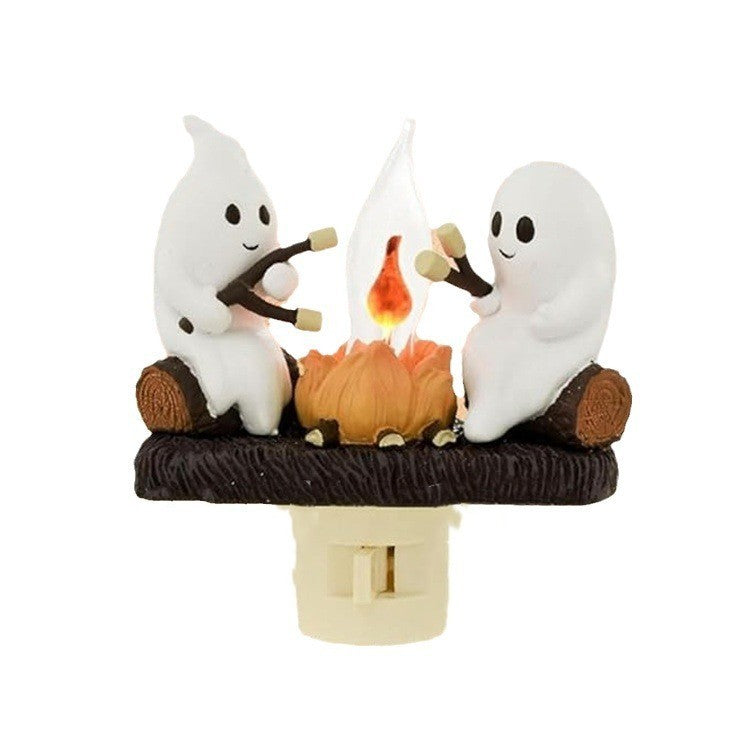 Cute ghost figurines around a glowing bonfire LED lamp