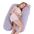 Woman lying on a large U-shaped pillow against a white background