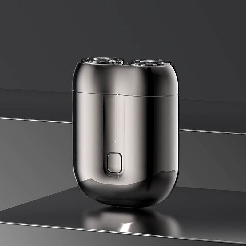 Shiny metallic electric shaver on a reflective surface with a dark background