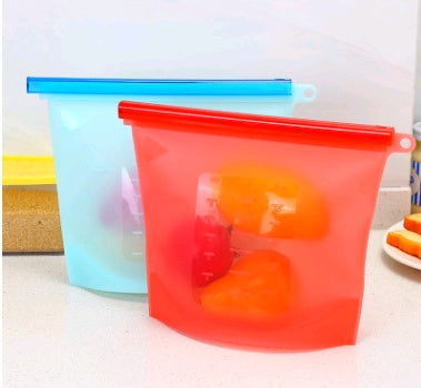 Two silicone food storage bags, one blue and one red, on a kitchen counter: Reusable silicone fridge food bag with seal