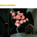Decorative LED rose lamp with pink flowers on a dark background