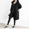 Person wearing a black coat and pants on a white background