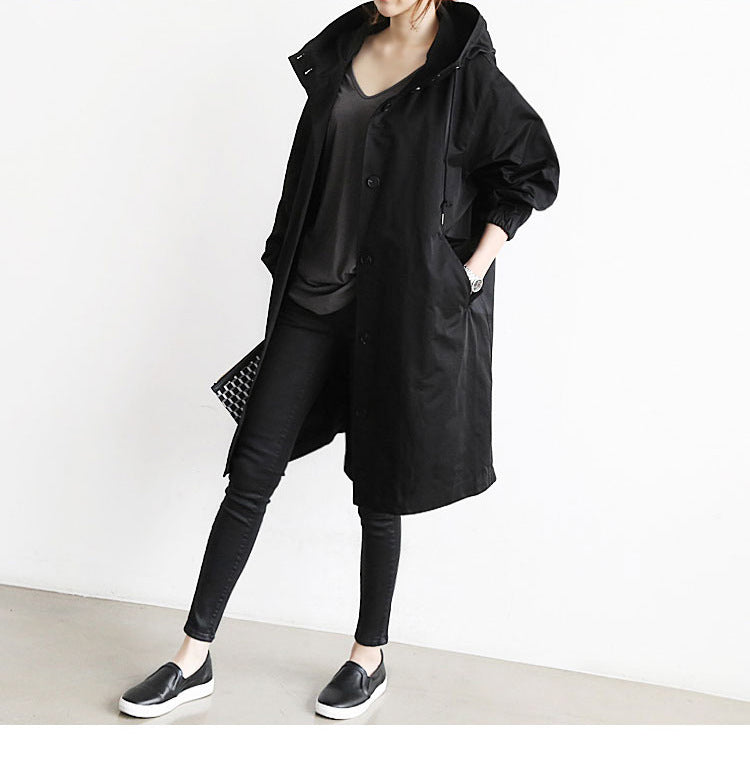 Person wearing a black coat and pants on a white background