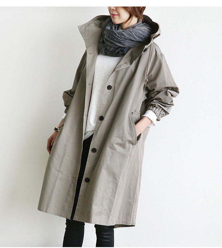 Person wearing a long gray coat with a hood on a white background