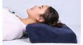 Person lying on a blue neck pillow against a light gray background