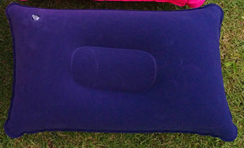 Five inflatable travel pillows in different colors on grass