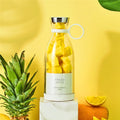 Portable rechargeable USB blender filled with pineapple pieces on a yellow background