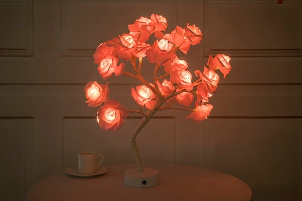 Two LED rose lamps, one red and one white, on a marble surface with a dark background.