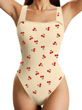 Beige romper jumpsuit with cherry pattern worn by a person on a white background