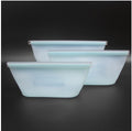 Set of three light blue glass bowls on a black background; Eco-friendly reusable food storage bags for travel and kitchen