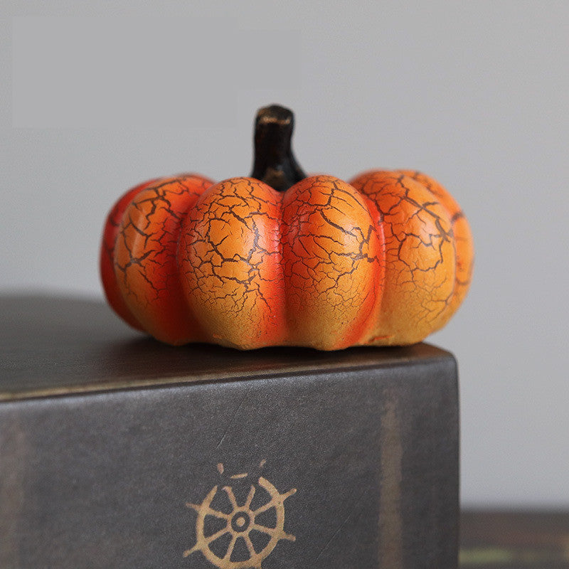 Small Halloween pumpkin decor light with cracked texture on a gray surface