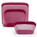Set of three pink plastic containers with lids on a white background