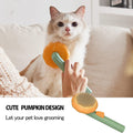 Cat being groomed with a pet brush featuring a pumpkin design, held by a person