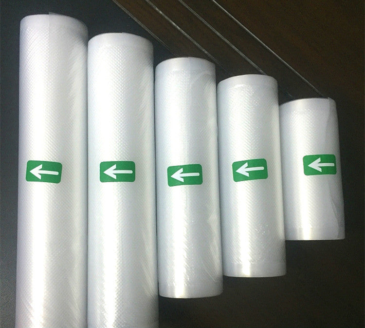 Five rolls of clear plastic sheeting with green directional arrows on a dark background