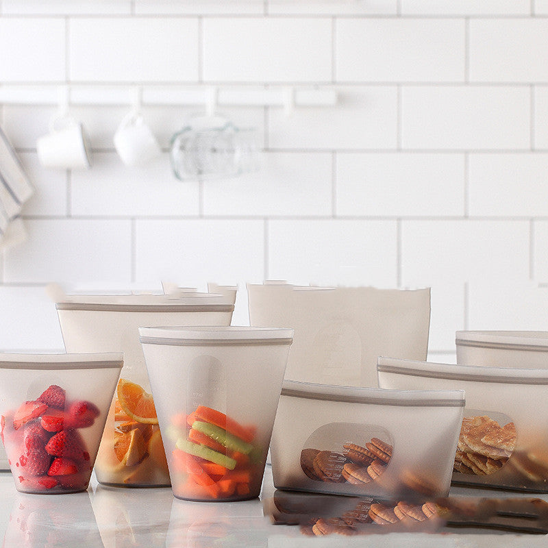 Set of food storage containers with snacks on a kitchen counter; Silicone vacuum sealed food storage bag