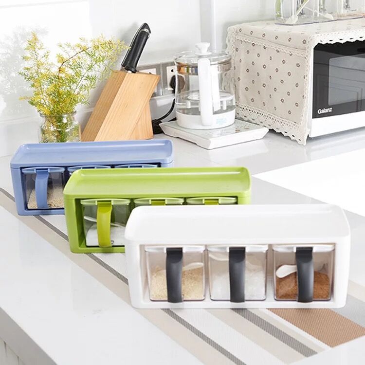 Kitchen counter with various containers including a knife block, water pitcher, and spice rack.