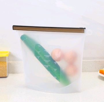 Reusable food storage bag with a green rolling pin and pink egg inside, on a white surface
