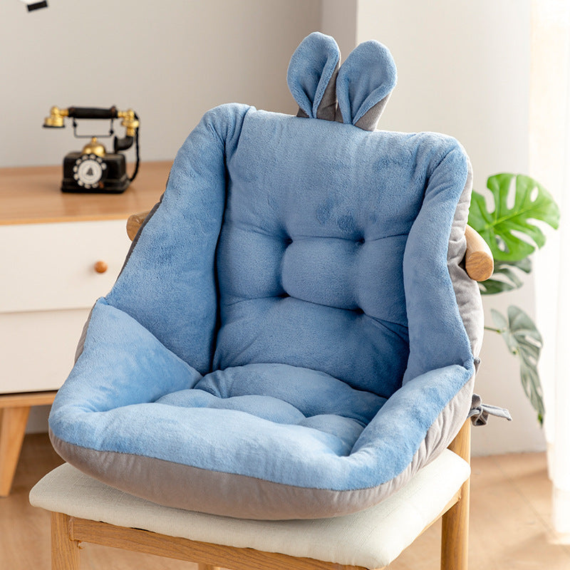Two chair cushions with bunny ears, one blue and one yellow, on a wooden chair in a room; Plush backrest-integrated chair cushion in neutral color