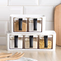 Stackable plastic spice rack with individual seasoning boxes on a kitchen counter