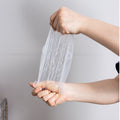 Two hands stretching a clear plastic sheet against a plain background