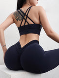 Person wearing a black sports bra and leggings against a light background