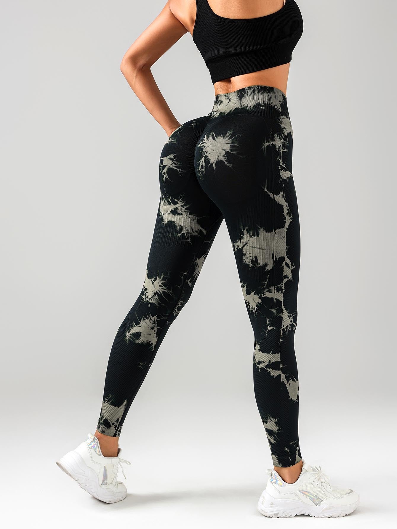 Black and gray tie-dye leggings worn by a person on a white background