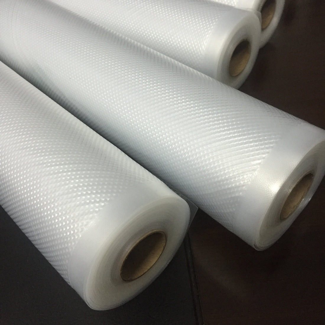 Clear plastic bag with red dates on a dark background; Vacuum sealer food storage rolls in multiple widths