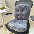 Gray cushion on a chair with a small table and book in the background; designed for comfort and support during long sitting hours