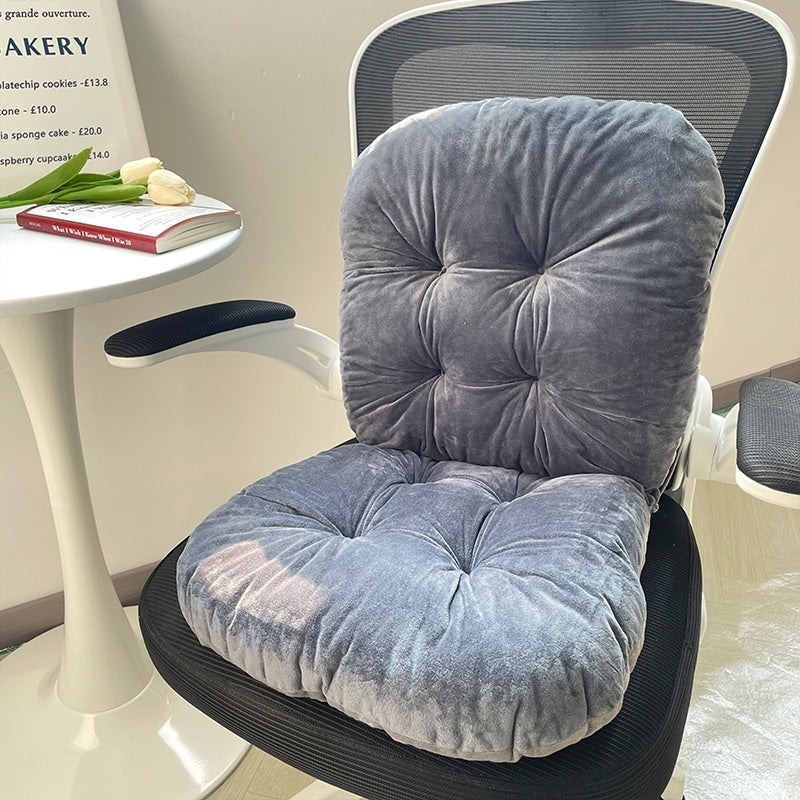 Gray cushion on a chair with a small table and book in the background; designed for comfort and support during long sitting hours