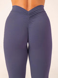 Purple leggings worn by a person on a beige background