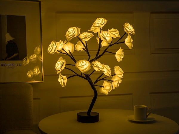 Decorative LED rose lamp shaped like a tree with illuminated rose flowers on a table.