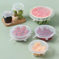 Set of silicone food covers on various fruits and containers on a light green background; Multi-size silicone bowl covers for kitchen storage