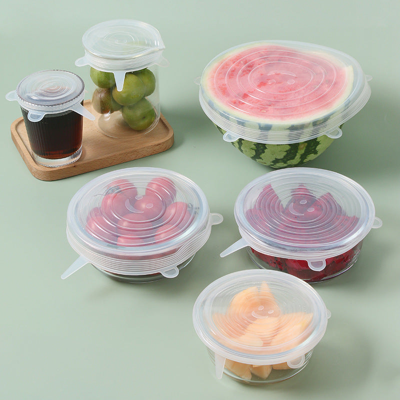Set of silicone food covers on various fruits and containers on a light green background; Multi-size silicone bowl covers for kitchen storage