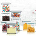 Set of clear storage containers with various food items on a white background