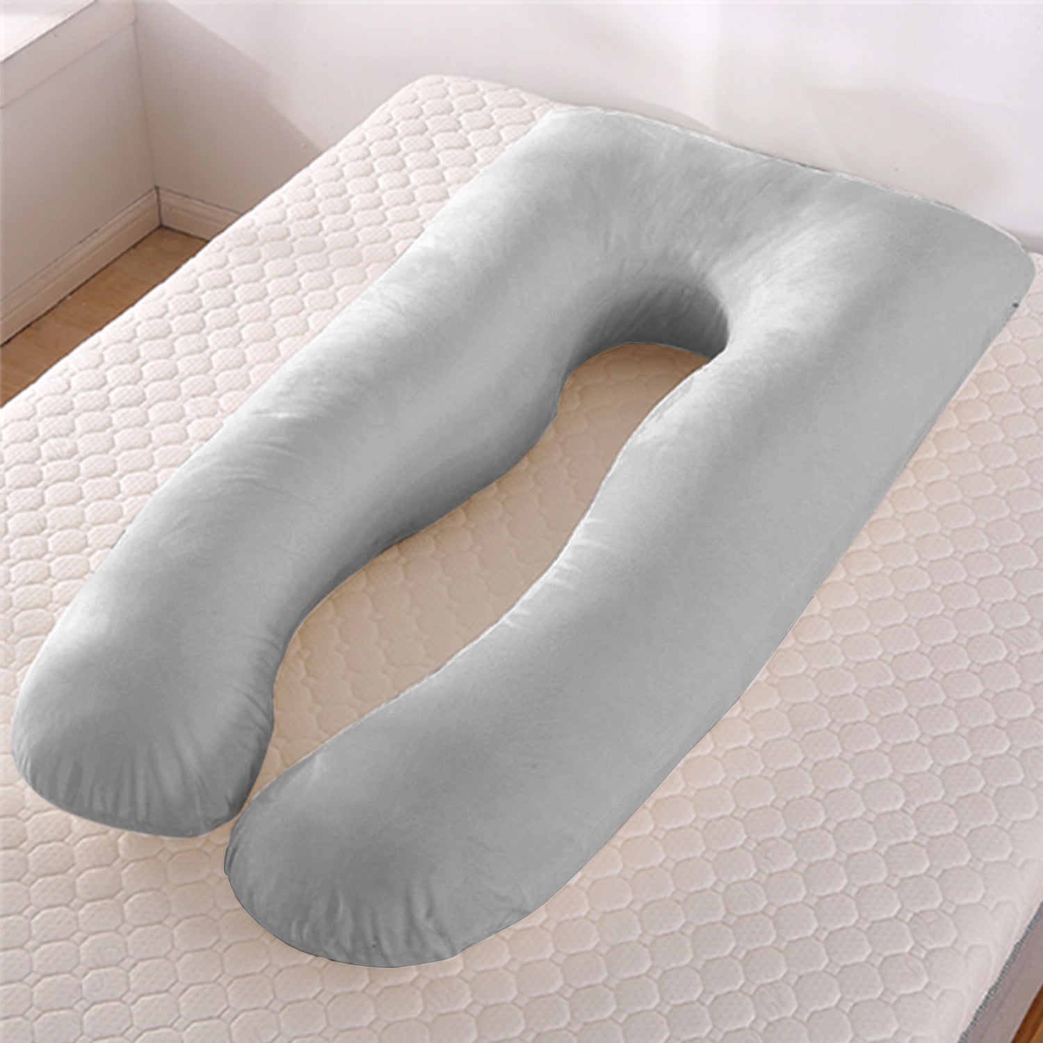 Gray U-shaped body pillow on a mattress