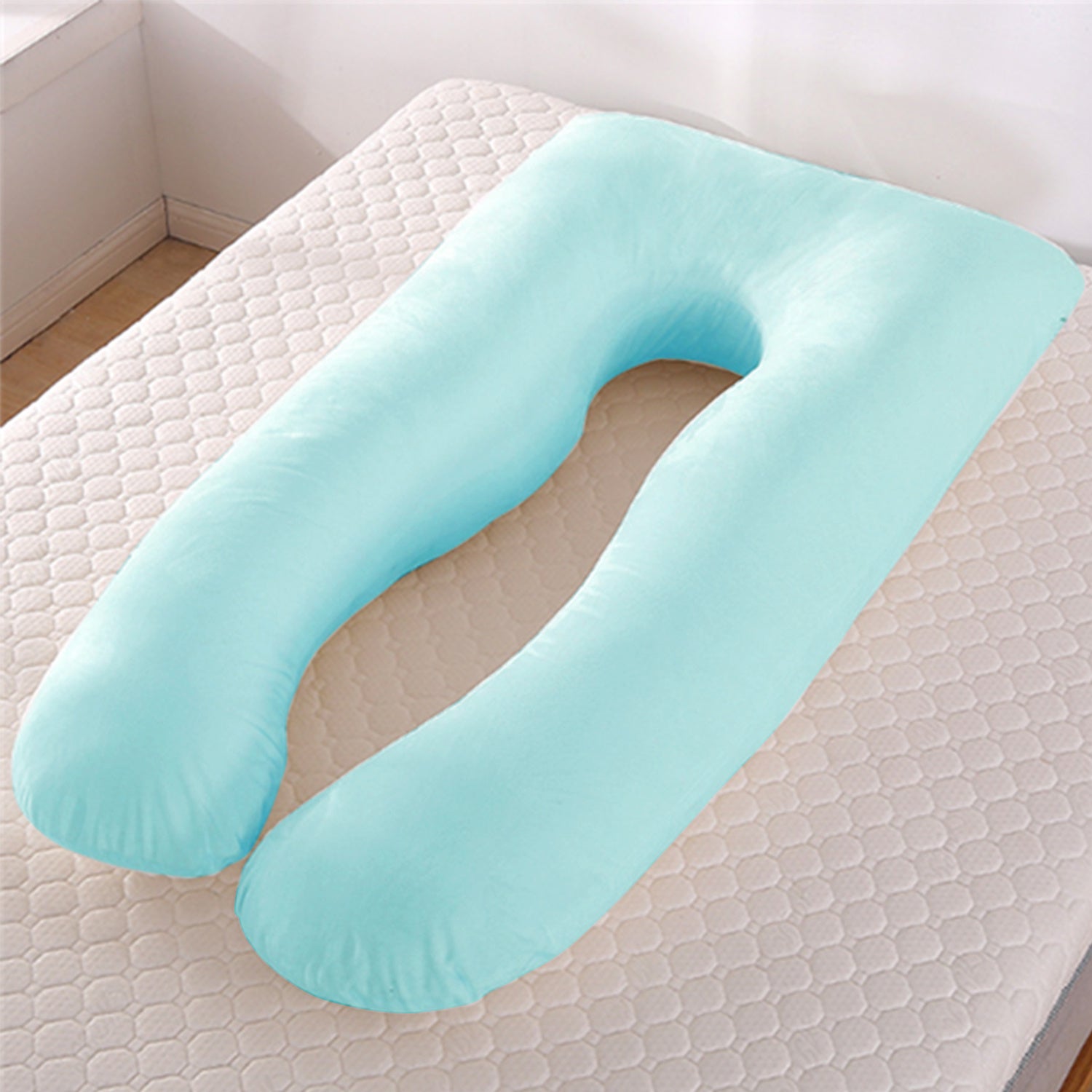 Light blue U-shaped pillow on a textured surface