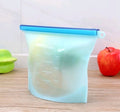 Gradient-colored measuring cup on a wooden surface with an apple and green container in the background