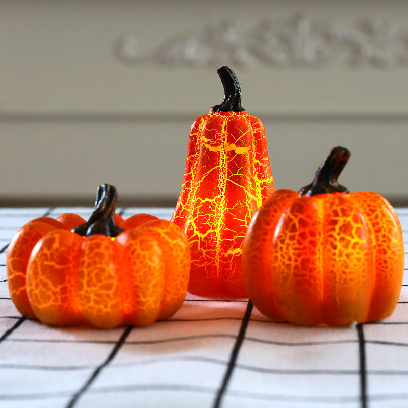 Decorative Halloween pumpkin decorative lights with a cracked texture on a tablecloth.