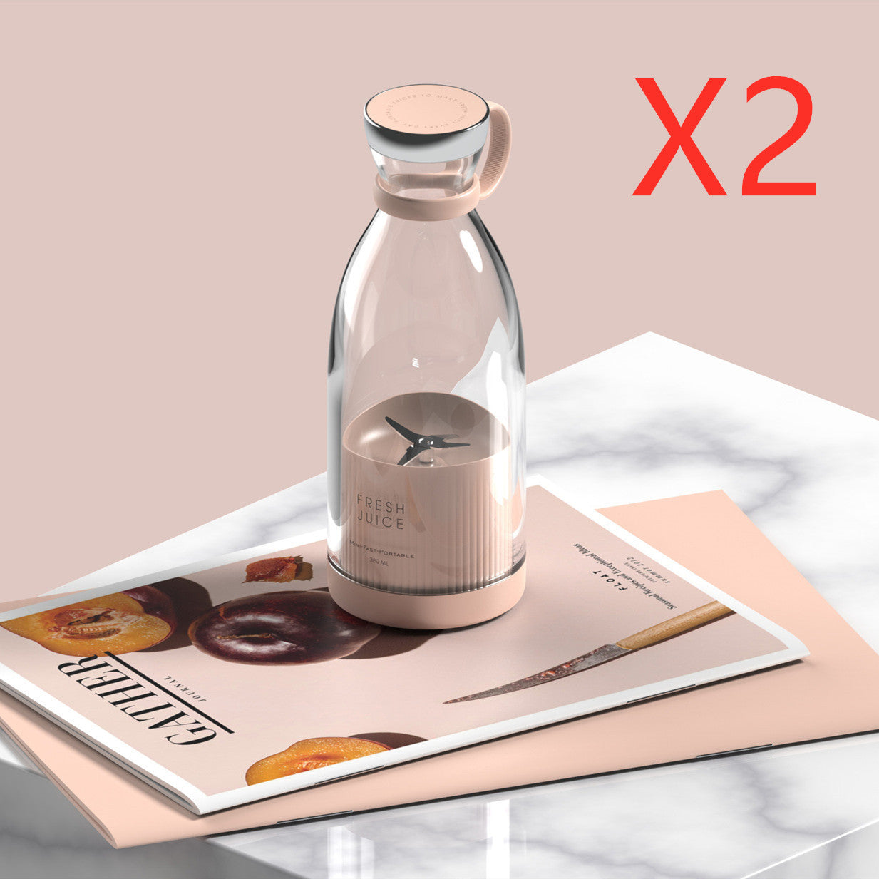 Clear Portable rechargeable USB blender with pink base on a magazine with a beige background