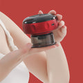 Hand holding a red and black electronic device against a red background