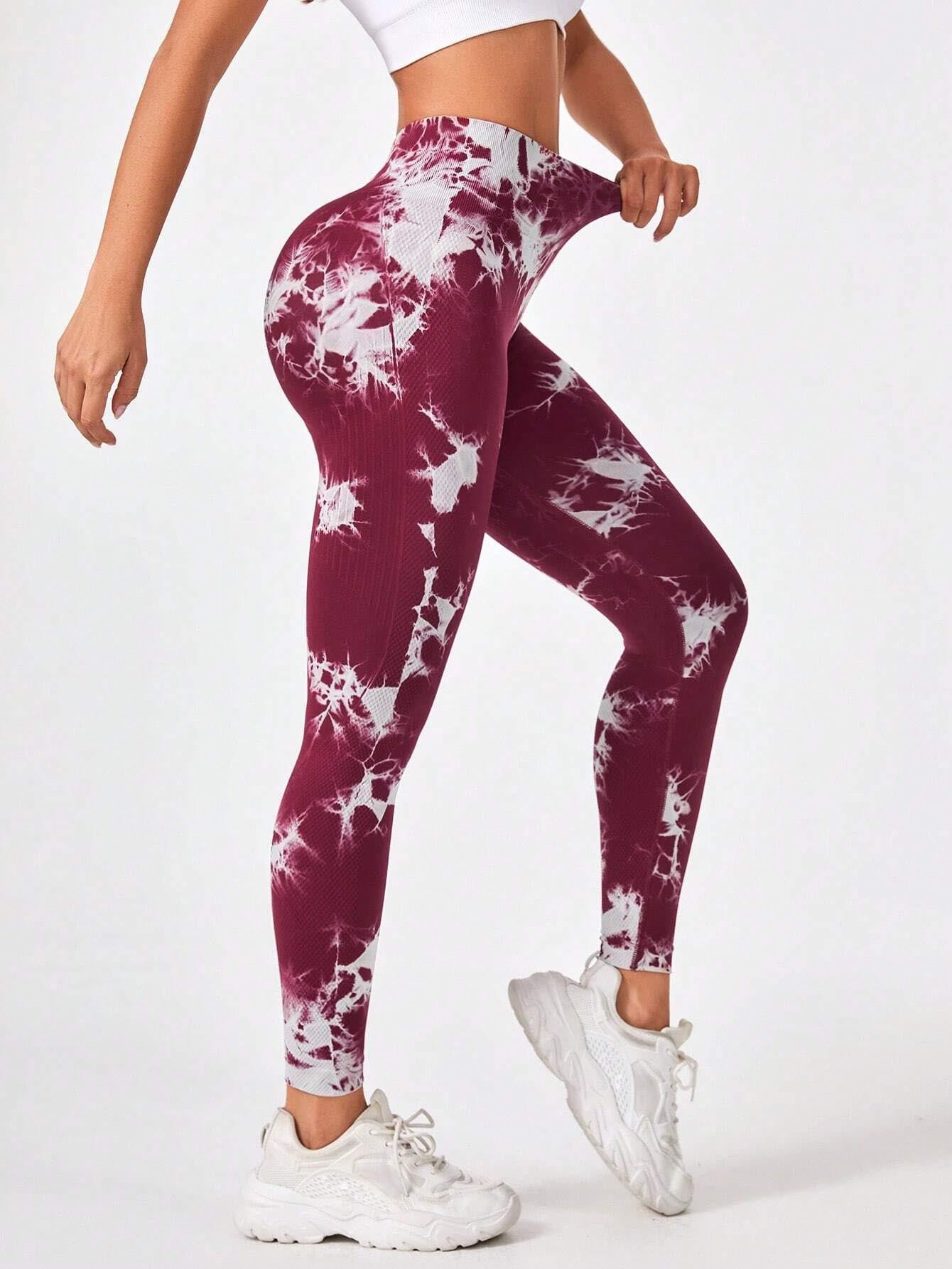Maroon and white tie-dye leggings worn by a person on a white background