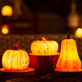 Three glowing Halloween pumpkin-shaped lights on a dark background