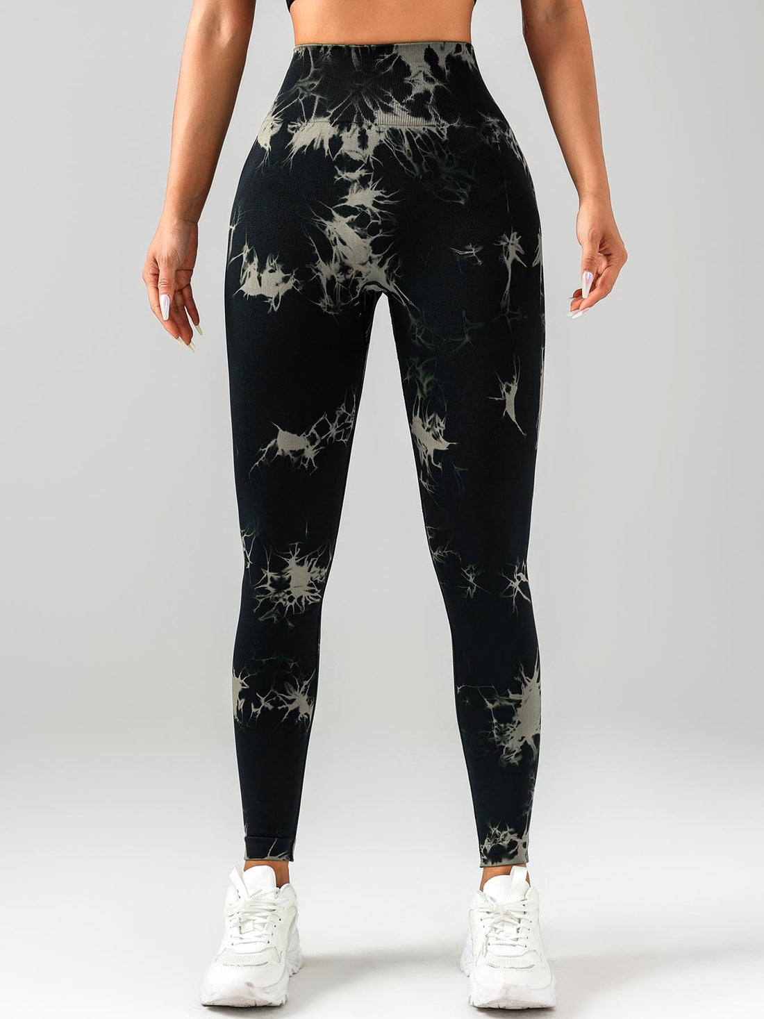 Person wearing black tie-dye leggings on a white background