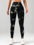 Person wearing black tie-dye leggings on a white background