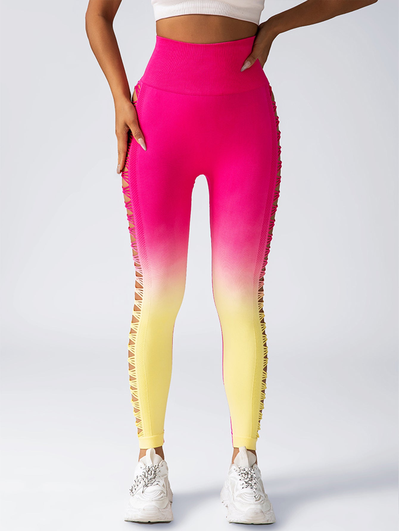 Gradient pink to yellow leggings worn by a person on a white background