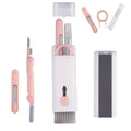 Set of pink and white skincare tools including a knife, comb, and other instruments on a white background.
