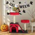Cat on a Halloween-themed cat tree with decorations and a pumpkin.