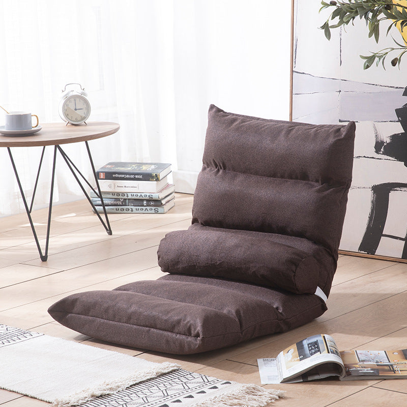 Brown floor pillow on a wooden floor with a table and books in the background; Foldable single lazy sofa recliner chair