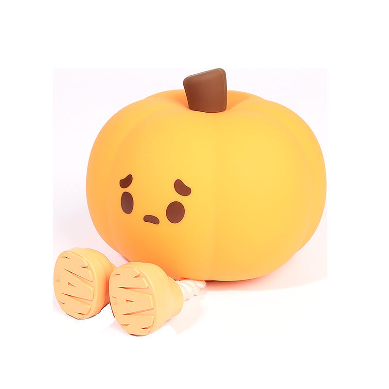 Pumpkin LED lamp with a sad face on a white background