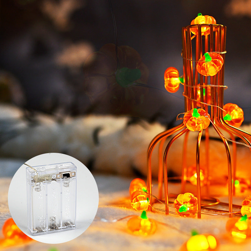 Halloween-themed string lights with pumpkins on a blurred background
